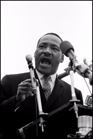 A powerful black-and-white photograph of Martin Luther King Jr. addresses the largest peace demonstration in history at the United Nations Plaza.
