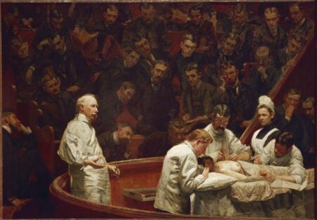 This is an iconic painting depicting a surgical scene in an amphitheater. A group of medical professionals, dressed in white, surrounds a patient on an operating table. In the foreground, a senior doctor gestures with authority, possibly addressing the audience. The background features rows of onlookers, predominantly men, watching intently. The composition emphasizes the drama and significance of medical advancement in a historical context.